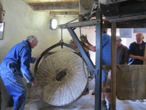 Then  the runner stone is  turned over to expose the milling surface, prior to being laid on its back.